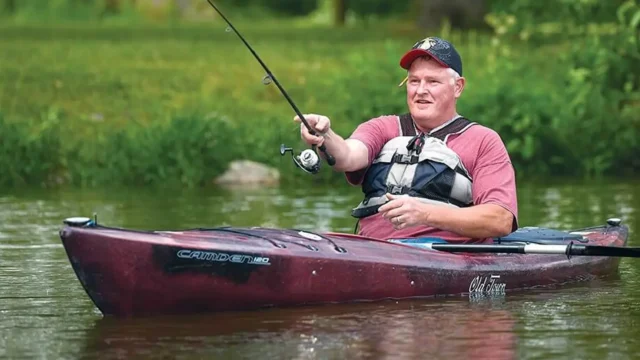 man sitting in a kayak fishing at lake loramie